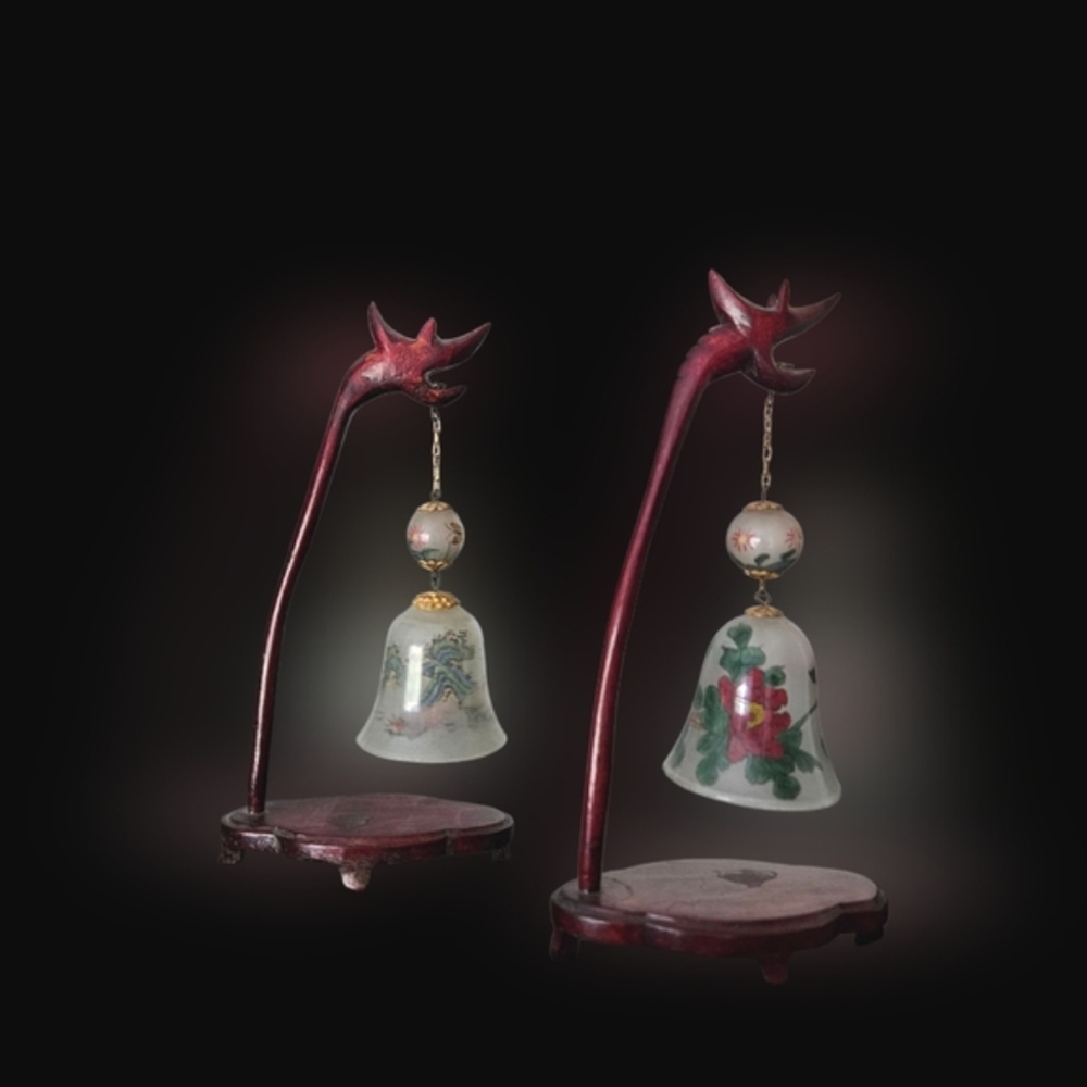 Two Vintage Chinese cloisonné bells hanging from a wooden dragon stands.